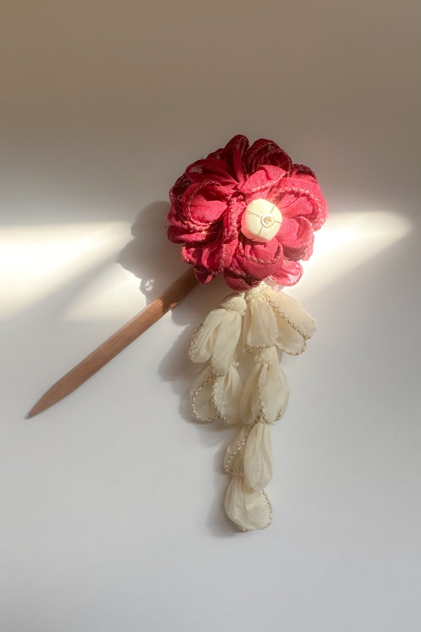 Hairpin with red flower and white lace on a light background