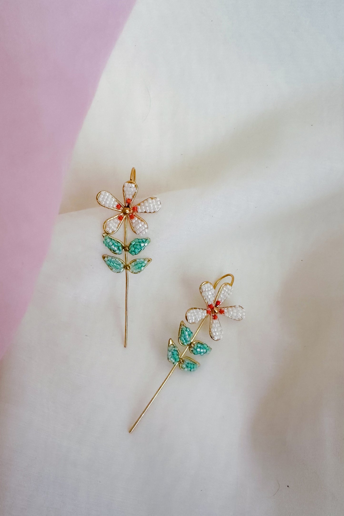 Decorative Earcuff with floral design on a soft pink and white background