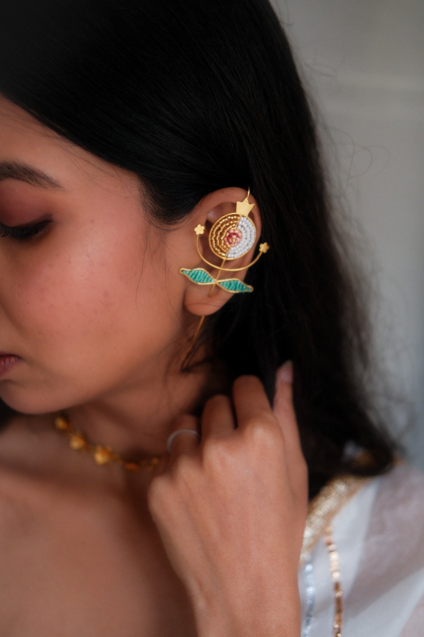 Close-up of a person wearing an ornate earring with intricate design.