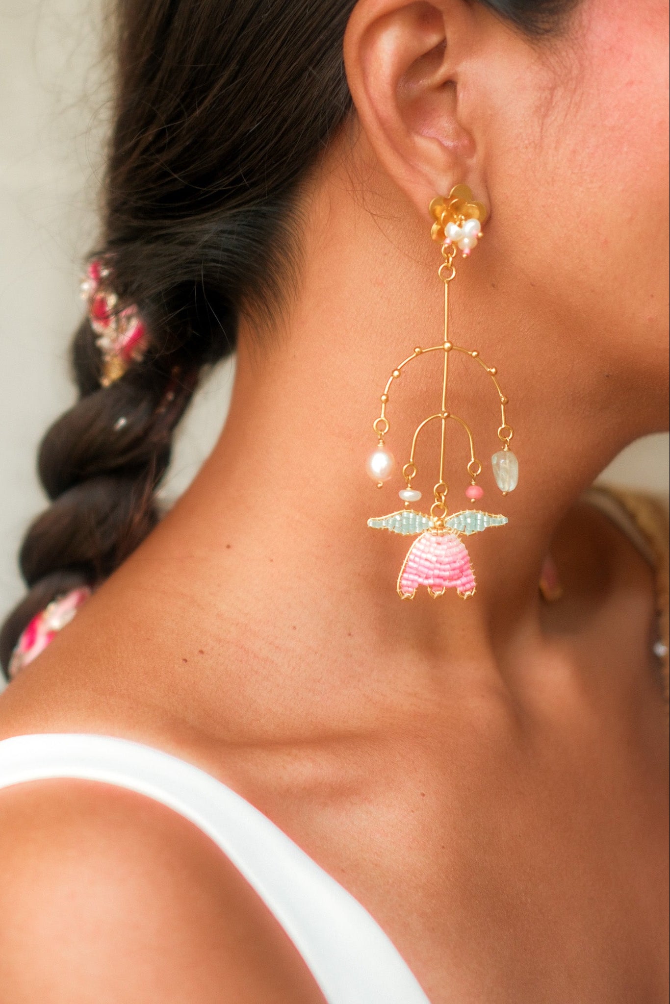 Close-up of a woman wearing a colorful Tulip shaped earring with a blurred background
