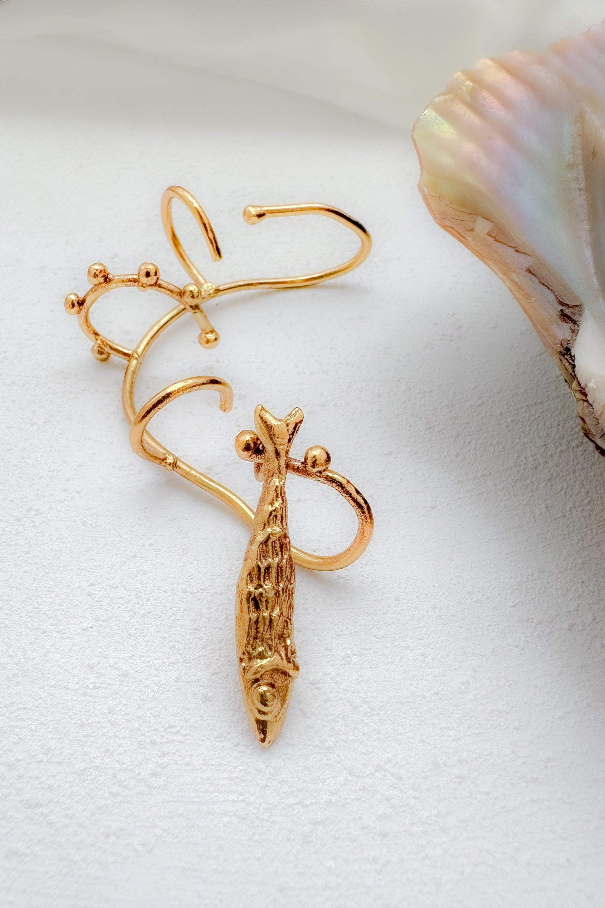 Adjustable ear stack with fish charm on a white background