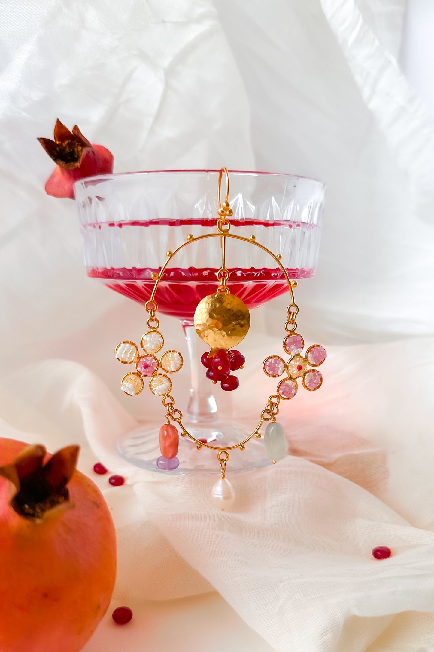 Pomegranate inspired statement earrings on a light background