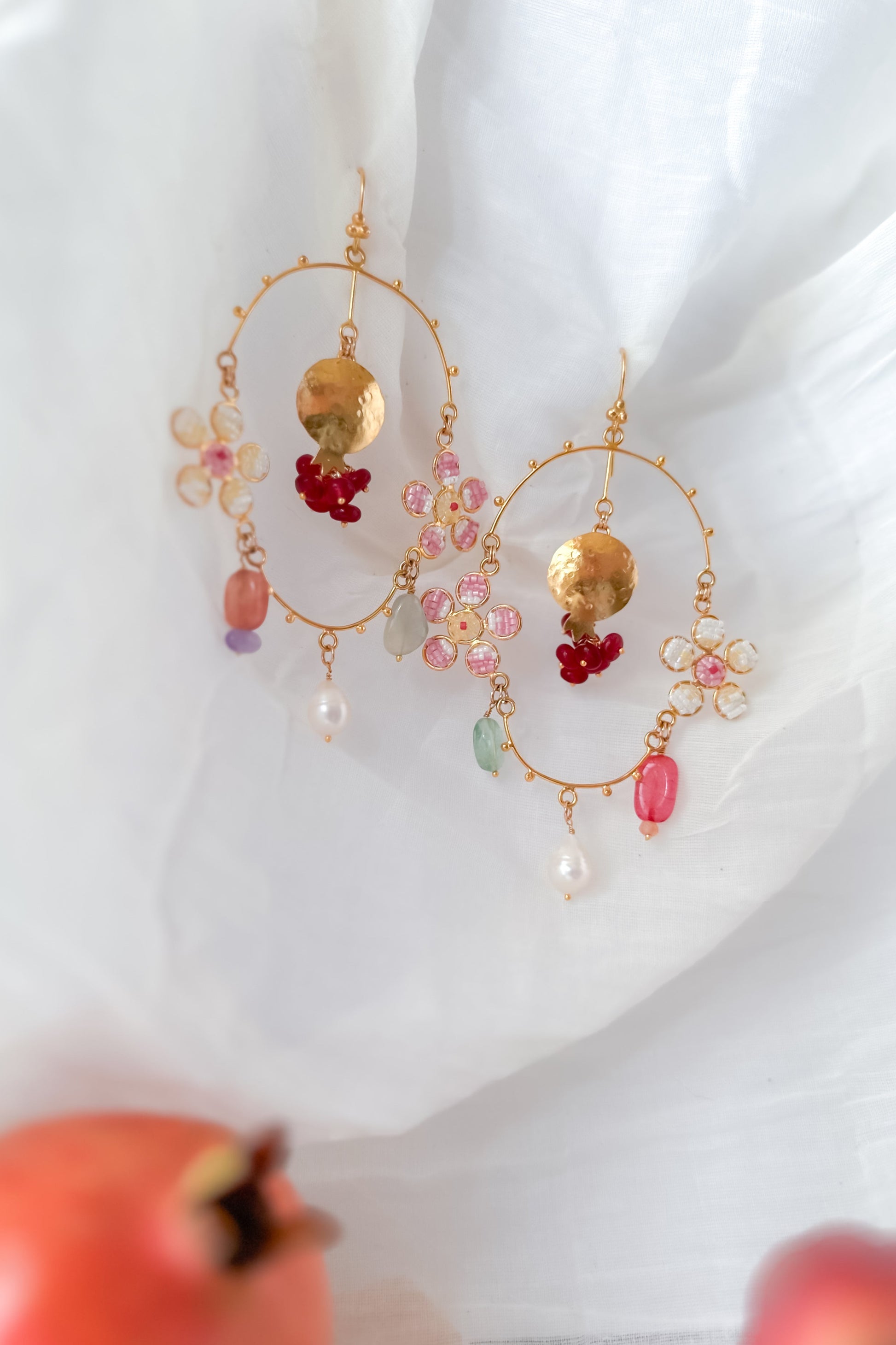 Decorative earrings with colorful beads and gold accents on a white background