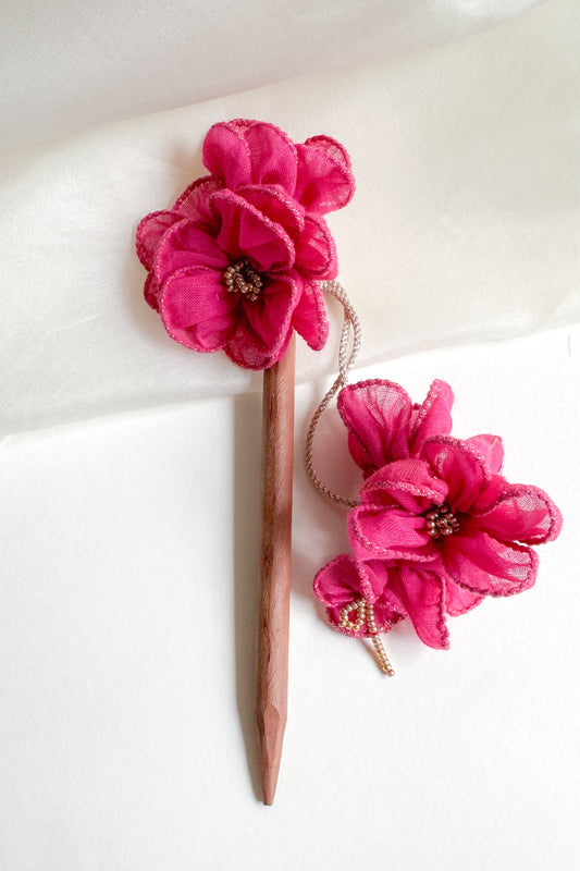 Hairpin with pink floral attachments on a white background