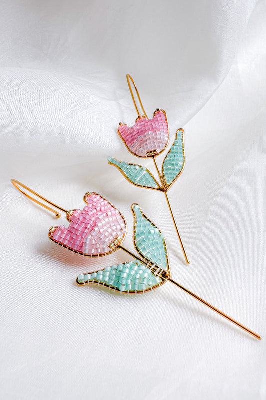 Decorative hair pins with pink and green floral designs on a white background