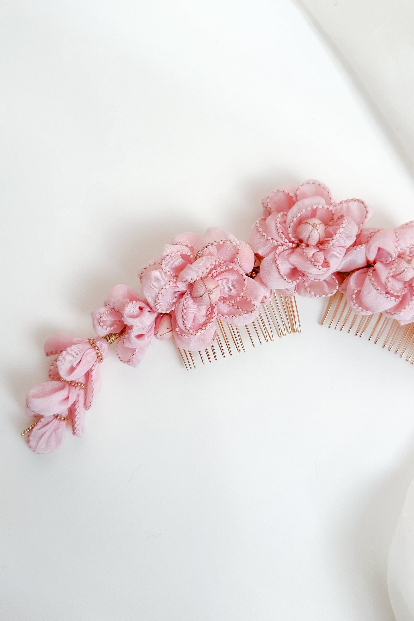 Pink floral headband with a comb on a white background