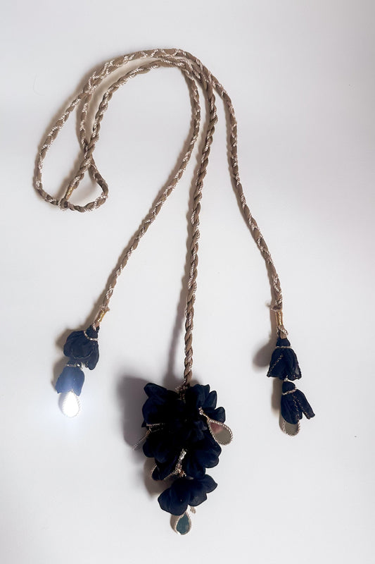 Parandi with black floral pendants on a Olive gold  braided cord against a white background