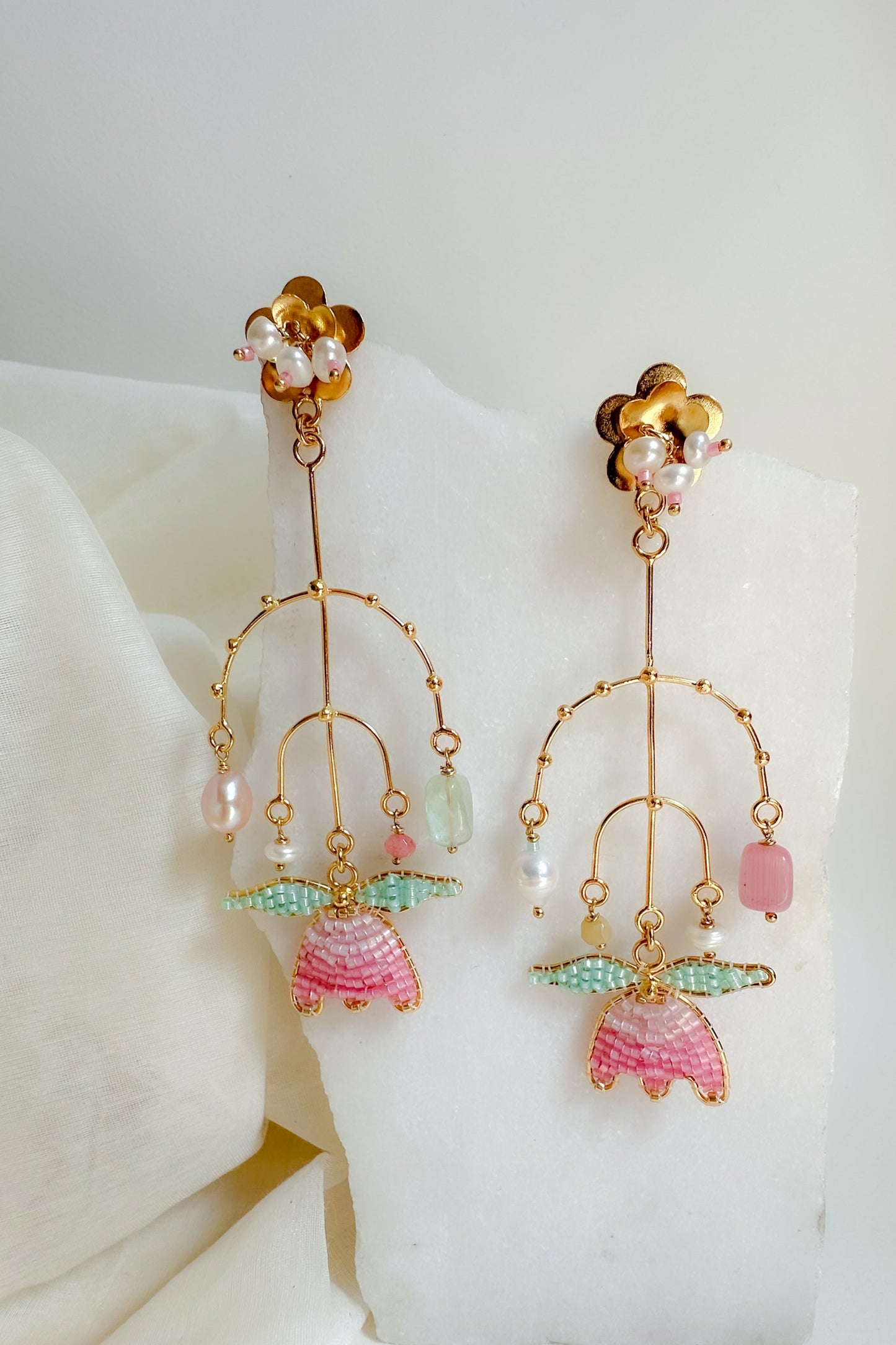 Pair of earrings with colorful beads on a white surface