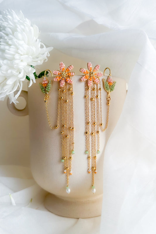 Decorative earrings with floral elements on a white background